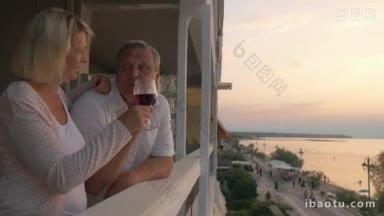 斯坦尼康拍摄的高级家庭夫妇在酒店的阳台上喝葡萄酒在度假村他们看风景的晚上
